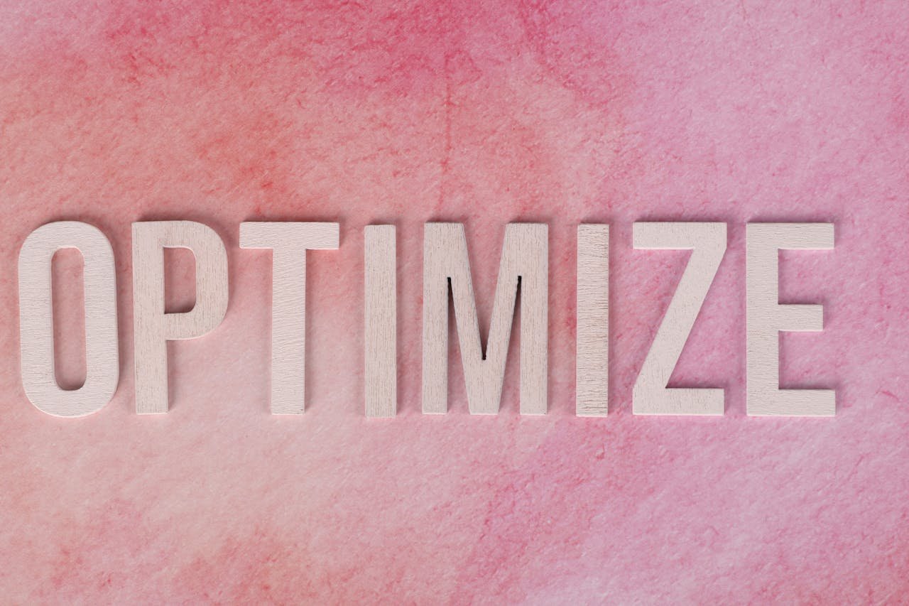 services-01 Creative display of the word 'OPTIMIZE' on a pink textured surface.